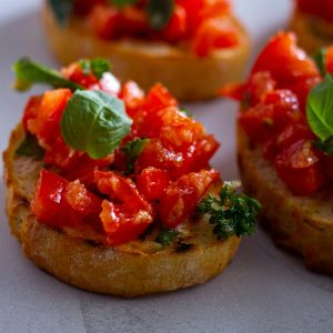 Delicious Italian bruschetta topped with fresh tomatoes and basil leaves, perfect for a snack.