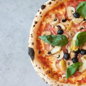 Appetizing pizza with fresh toppings on a gray background for a perfect meal shot from above.