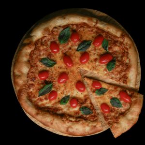 High-angle view of a Margherita pizza with cherry tomatoes and basil on a wooden board.