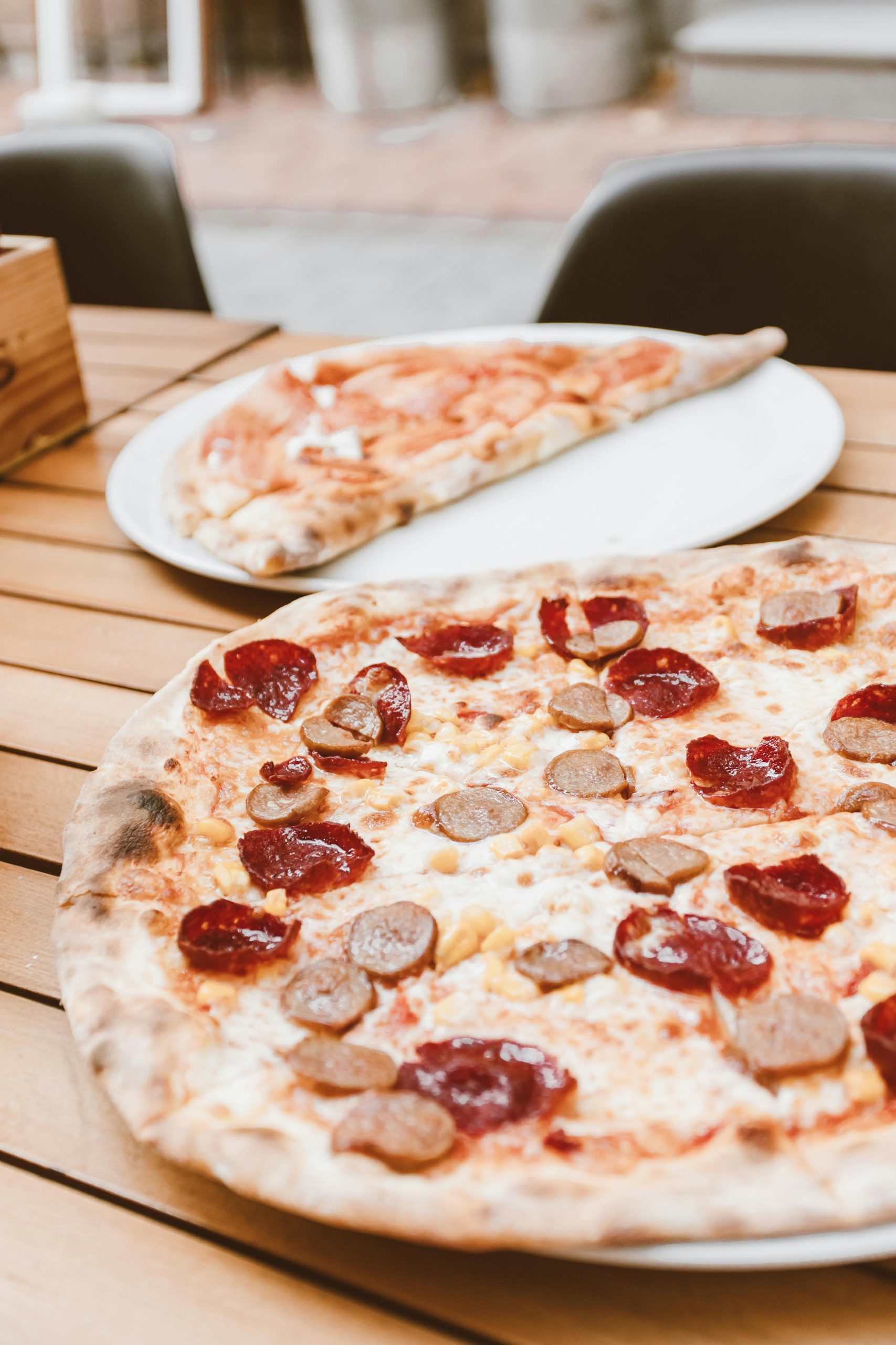 Close-up of pepperoni and sausage pizza on a wooden table, perfect for a tasty meal.