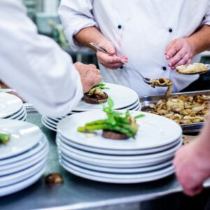 Chefs prepare and plate gourmet dishes in a professional restaurant kitchen.